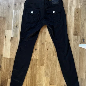Svarta lågmidjade true religion jeans - Säljer dessa svarta lågmidjade leggings/jeans från true religion. De är stretchiga och tajta. Jätte bra skick!! 