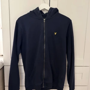 Lyle & scott- dragkedje tröja med huva - Använd ca 3 gånger men super bra skick, ordinarie pris ca 750. Säljer då den är lite för stor på mig och fick inte mycket användning av den.
