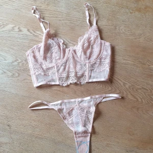 Topshop set "Hannah" - Top shop. Nytt oanvänt set med bh och ett par stringtrosor i rosa spets. Lappar och skyddsfilm kvar. Bh- storleken satt tyvärr inte bra på mig, så säljer därav.   Bh storlek 70C och trosor i S