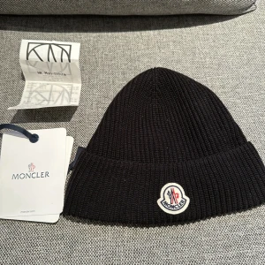 Moncler mössa  - Säljer min moncler mössa!  Den är sparsamt använd aldså i nyskick! köpt på NK Stockholm för 1900kr  Tags och kvitto finns! Samt QR i mössan! Hör dig vid ev frågor! 