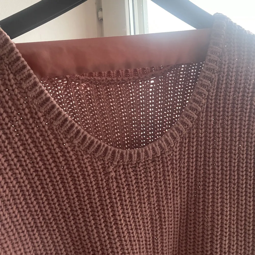 Fin stickad tröja. Färgen är typ rosa fast mer soft. Har ett rosa band i ryggen. Trekvartsärmar. Stickat.