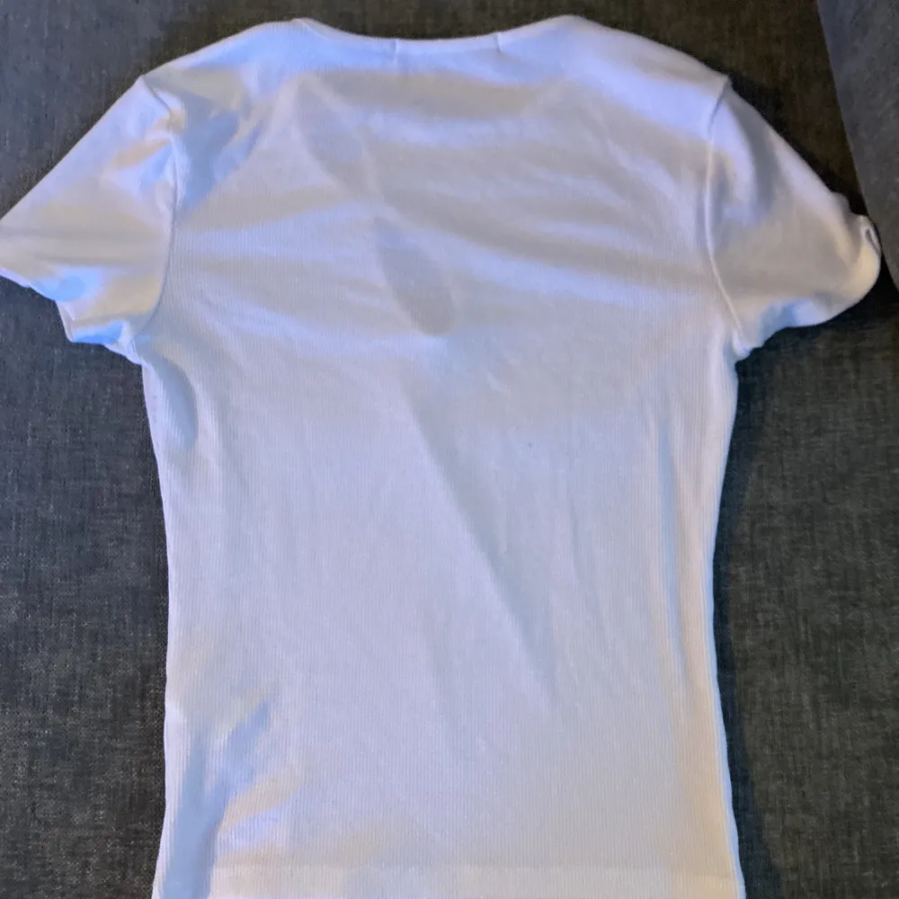 Skön vit t-shirt men knapp detalj. Nästan aldrig använd . T-shirts.