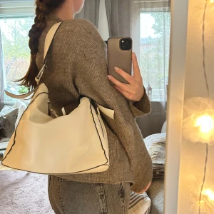 Vit påsväska  - En snygg vit påsväska med silvriga detaljer som funkar till allt! Liten och behändig men får plats med mycket. Små defekter i nedre kanten som syns på bild 3. Hör gärna av dig vid frågor. Köparen står för frakten. Möter gärna upp i Uppsala💕