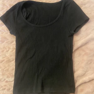 Svart ribbad t-shirt - Svart ribbad t-shirt från H&M. Köpt för längesen men skicket är fint! Inga defekter på tröjan. Sitter som xs-s. Sista bilden är hur den sitter på fast i en annan färg.