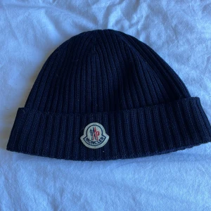 Moncler Mössa - Hej! Säljer nu min Moncler mössa eftersom jag aldrig använder den! Köpt i julas på NK för 1 699kr och kvitto finns även. Den är i 9/10 skick och använd fåtal gånger!