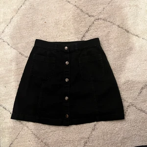 Jeans kjol - Svart jeanskjol från Monki med knappar. Köpare står för frakten:)