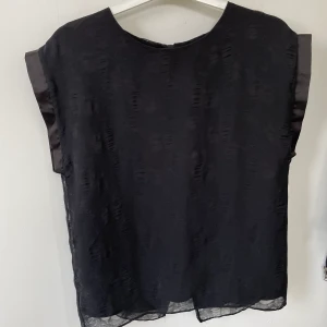 Svart fintröja  - Väldigt fin svart tröja I härligt material med fina detaljer vid armarna och ryggen! I väldigt fint skick! 