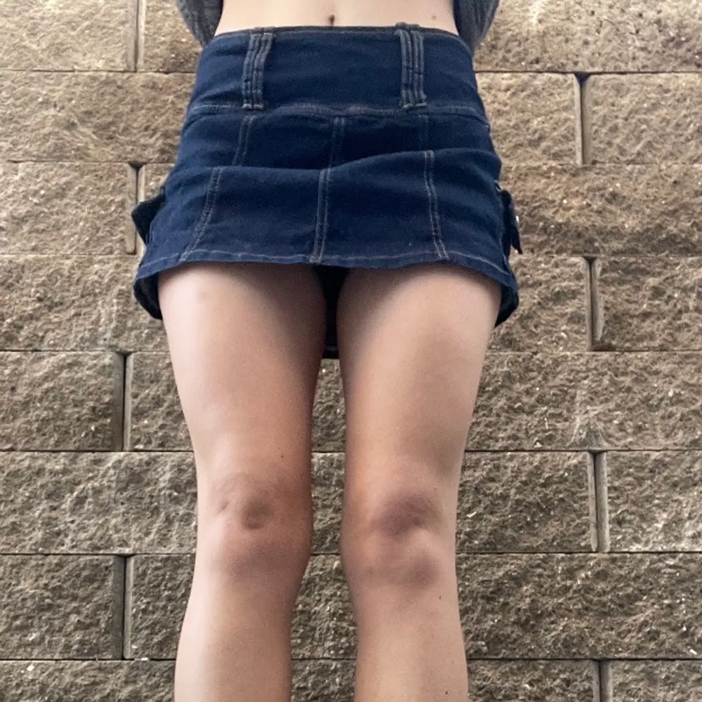 Kort, mörkblå jeanskjol med inbyggda shorts under, så det gör ingenting att den är kort! Riktigt tuff kjol med detaljer och fickor, bra kvalitet och bekväm.. Kjolar.