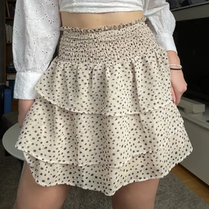 Prickig volangkjol! - Jättesöt beige och svart prickig volangkjol från H&Ms barnavdelning. Är i storlek 170, men passar bra på mig som är 175 och brukar ha storlek S/M. Volangerna är lite snedskurna också, och är knappt använd! 90 + frakt 🚚❤️!