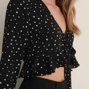 Kort prickig blus - Säljer denna söta blus som jag köpt från NAKD. Använd 1 gång så är i bra skick! Fin till fest eller middag. Finns fortfarande kvar på deras hemsida och kostar 269kr
