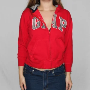 Röd Hoodie från Gap - Cool röd hoodie med dragkedja i superskick från Gap. Är i barnstorlek men jag kan ha den och jag är en S/M. Lite kort i armarna men annars sitter den bra. För mer frågor om passform och frakt m.m. Är det bara att höra av dig!