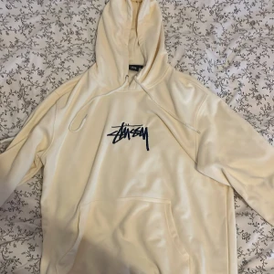Creme Stussy Hoodie - Hyfsat ny och köpte den för någon vecka sen, ville direkt inte ha den så jag säljer den nu👍