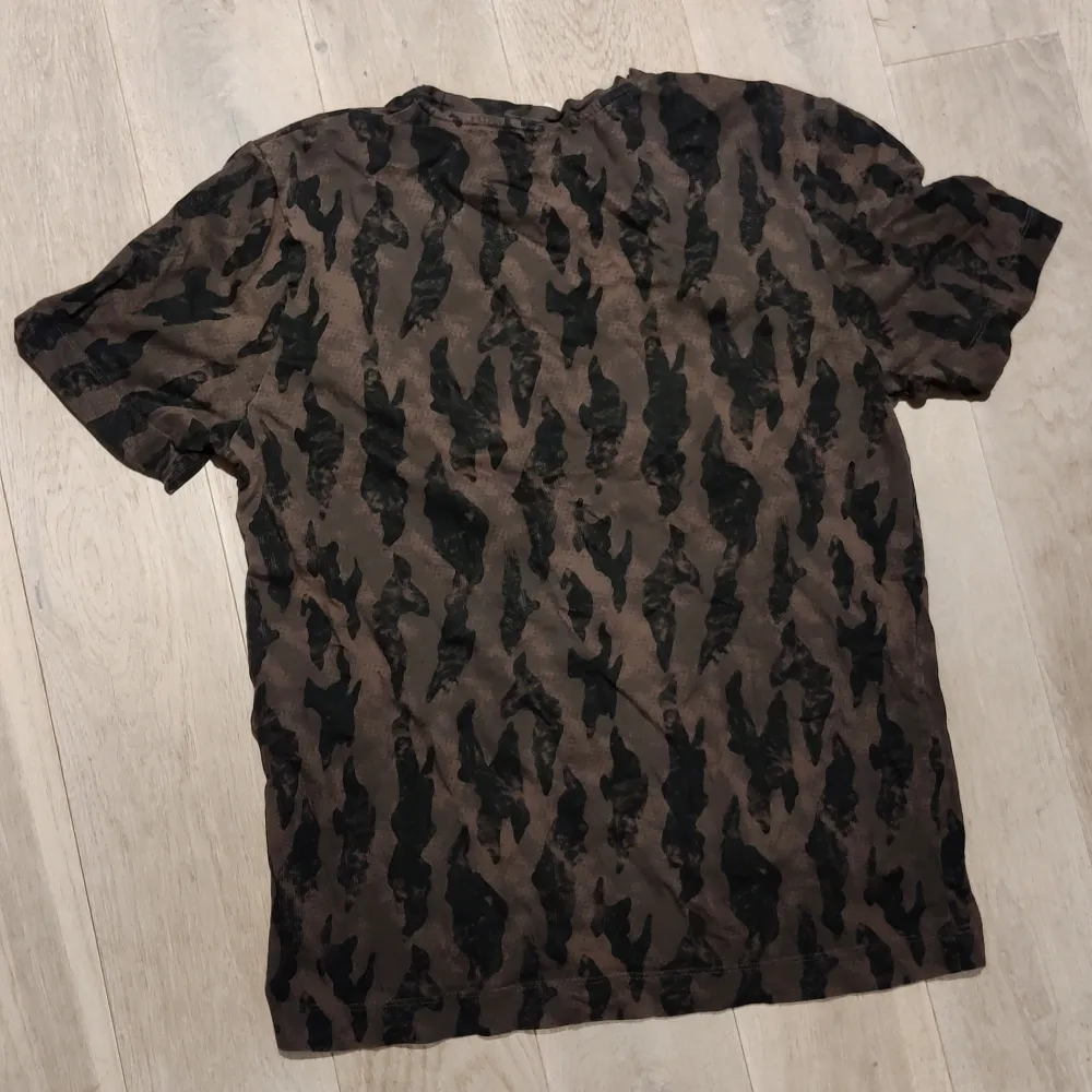 Sparsamt använd t-shirt från visual clothing project. Snyggt brun/svart mönster. T-shirts.
