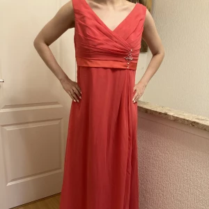 Rosa långklänning  - Elegant och enkel i modellen. Lite stor för mig på bilden men optimal för en 38a/M. Detalj på ena sidan. Skickar fler bilder vid intresse.