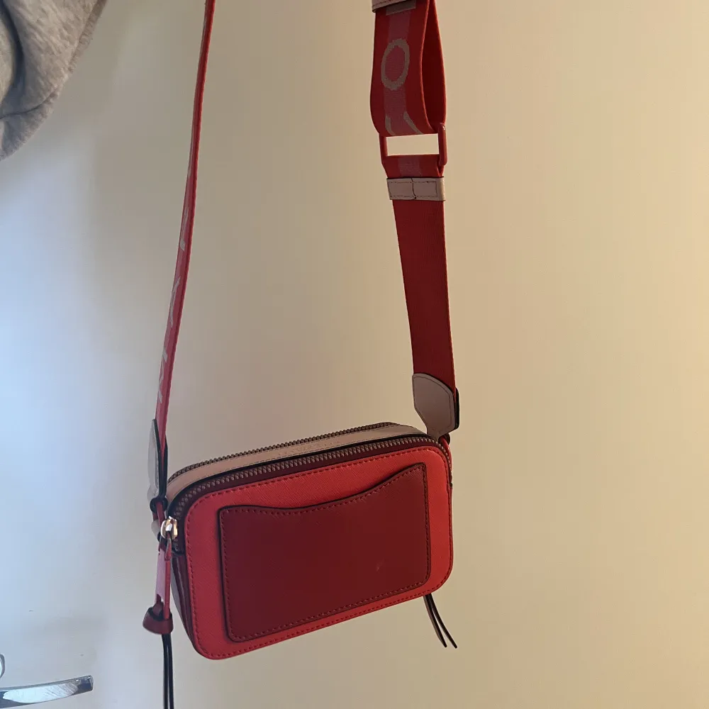 Säljer denna snygga Marc Jacobs väska❤️ väskan är röd med rosa detaljer.  är i hyfsat bra skick.  . Väskor.