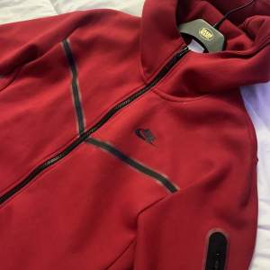 En röd nike tech fleece som köptes från hemsidan i oktober, säljs pga ingen användning till den längre och ligger bara i garderoben🫶 För mer frågor och bilder, kontakta mig🤍