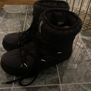 Svarta moonboots strlk. 38 - Så snygga låga moonboots i svart i strlk 38!😍❤️ Nästan oanvända, köpta för 2100 kr.