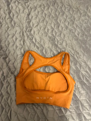 NVGTN top - I färgen burnt orange. Ger bra stöd och har vadderade kupor. 