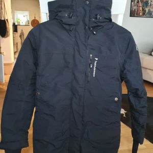 Peak Performance dunjacka XS-S.  - Superfin parkas i stl XS, men passar också S.  * Tvättad och tumlad med tennisbollar. * Inköpspris över 4000 kr. * Fyllning: 80% ankdun, 20% ankfjäder * Avtagbar huva.  Finns i Sollentuna för avhämtning eller skickas.