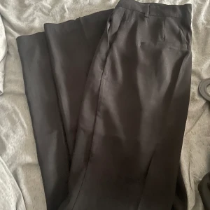 Kostymbyxor med slits  - Snygga kostymbyxor med slits från nakd. Använda en gång 