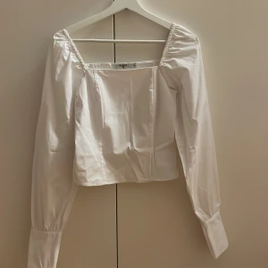 Vit blus NA-KD - Vit blus från NA-KD i strl 34! Väldigt fint skick användt endast 1 gång.