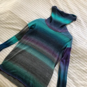 Stickad tröja - Tunnt material som är superskönt i en lång tunika som sitter snyggt med lite oversize stuk. Går nästan att ha som klänning. Hög krage. Strlk L. Funkar för XS-L beroende hur man vill att den sitter. Unik o finns ej att köpa i butik är från 00 tal. 