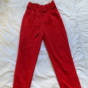 Röda kostymbyxor - Jättefina kostymbyxor med skärp till. Använda 1 jul. Passar S också