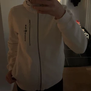 Sail Racing kofta med hög krage och huva - Säljer min vita Sail Racing kofta eftersom den inte kommit till användning. Den köptes i somras men har bara används ca två gånger så den är som ny. Köparen står frakten men kan även mötas upp i Blekinge. Skriv för frågor om betalning osv!