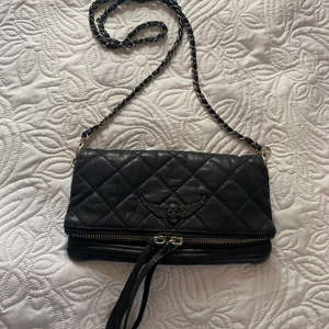 Zadig & Voltaire väska - En ascool zadig & voltaire väska med döskalle symbol. Svart läder. Har bara långa remmen men kan vikas inne i väskan så det även blir som ett kortare band! Har några småfläckar och slitningar men absolut inget man tänker på! 