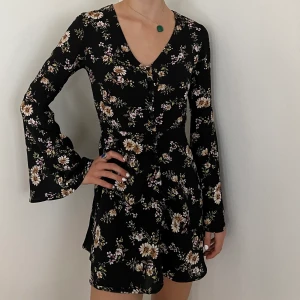 Blommig klänning  - En blommig klänning i svart och färg från oklart märke men i gott skick. Köparen står för frakten 