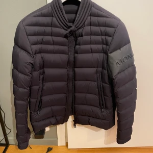 Moncler Arre size 2 - En stilren mörkblå jacka i bra skick använd endast ett fåtal gånger. Skick 8,5. Kvitto finns samt mer bilder.
