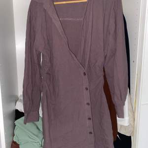 En snygg asymmetrisk skjortklänning i brun. Aldrig använd köptes för 400kr