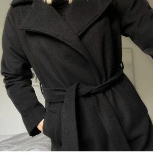 Lång kappa, strl. S från BIKBOK - Lång svart kappa från Bikbok i strl. S. Fint, använt skick.