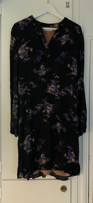 Klänning Noa noa stl 42 - Klänning Noa Noa i mörkblått med lila/beige/blå/orange mönster, stl 42. I fint använt skick som definitivt har mer att ge.