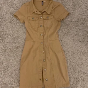 Beige klänning  - Säljer denna beige ”Cargo” klänning. Köpte för ett tag sedan, säljer då den ej passar längre då jag är strl 34. Därför har jag ej bilder där den är på. Den är i strl 32, motsvarar alltså xxs. Säljer för 175kr. 