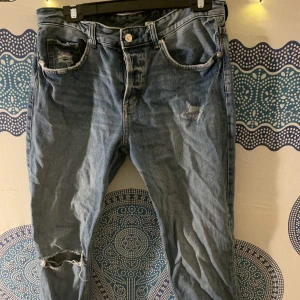 Jeans - Jeans med slitna detaljer, låg midja och 30 i storlek.