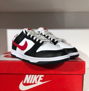 Nike Dunk Red Swoosh Panda - Säljer dessa Nike dunk red swoosh panda, storlek 41. Dom är hela nya och oanvända. Digitalt kvitto finns från köpet, box medföljer. Skriv för fler bilder/frågor.