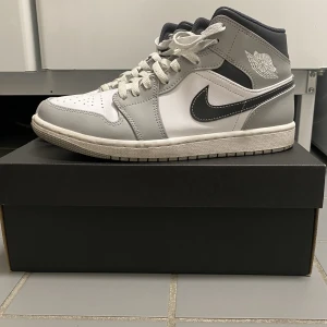 Air Jordan 1 Mid 'Light Smoke Grey' - Säljer Air Jordan 1 Mid 'Light Smoke Grey' storlek 42 i myxket bra skick, finns knappt skador eller smuts. Endast använd ett par gånger (pris kan diskuteras)