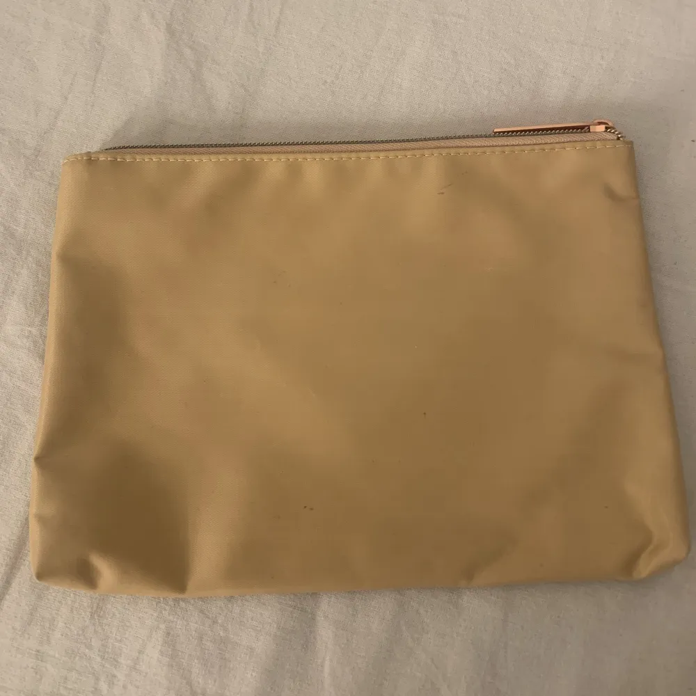 En beige/guldig sminkväska från makeup mekka. Aldrig använd . Väskor.