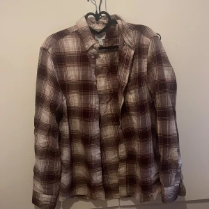 Skjorta strl S  - Röd-brun-vit rutig skjorta som är köpt för längesedan men är knappt använd.