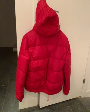 Vintertäckjacka med luva - Röd varm vintertäckjacka med luva.