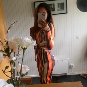 Lång klänning - Lång multiförgad klänning åt det oranga hållet, med knytning vid magen🌸 Använd en gång, som helt ny