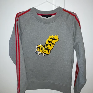 Marc Jacobs Sweatshirt - Marc Jacobs sweatshirt in gray with res stripes on the arms and a tiger claw as motive. You can still buy it at Farfetch for 300 euro. Used only once. Size S and true to size. Shipping within Sweden is included in the prize.