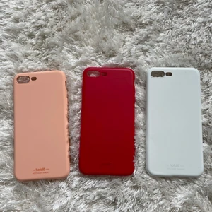 iPhone 7/8 plus skal - 3 skal från Holdit. Rosa skalet är oanvänt, det röda har en liten spricka i kanten (se bild) och den vita har en större spricka samt en slitning på ena sidan (se bild). Alla är i bra skick och går att att använda! Originalpris är 149kr/skalet.