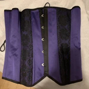 Lila korset  - Lila korsett med långa snören. Aldrig använd.