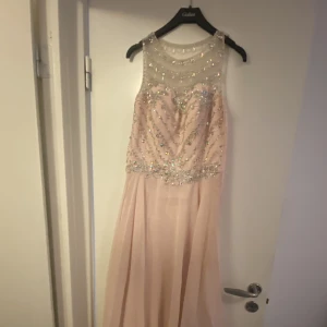 Festklänning med paljetter - Säljer min ljusrosa festklänning som endast är använd en gång. Det finns inga skador eller några felaktiga märken.