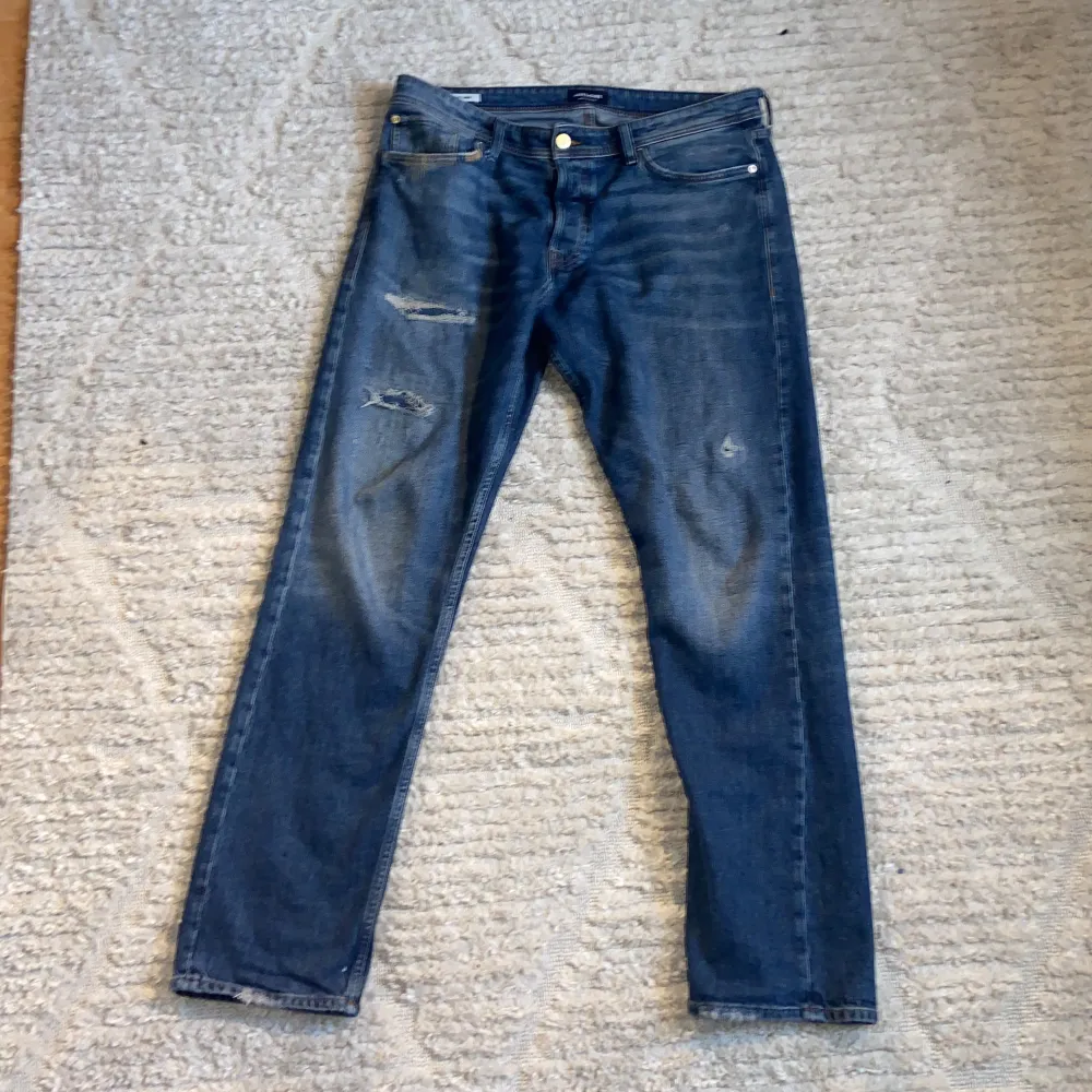 A pair of bluejeans in size 36/36 or XL. They have a ”ripped jeans” design and are barely used. Apart from the rips that show on the pictures the jeans also have ripping details on each back pocket. These jeans have a quite loose fit, im pretty big tough . Jeans & Byxor.