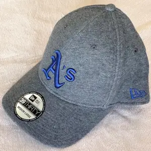 Oakland Athletics baseballkeps. Mörkgrå med blå logo. Stl. Medium-Large