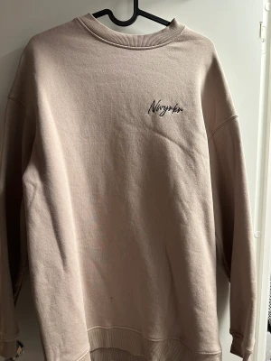 Ljusrosa/beige tröja med tryck på ryggen - Ljusrosa/beige tröja med tryck på ryggen i fint skick