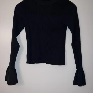 Stickad tröja med trumpet arm - Stickad tröja med öppen rygg, från Gina tricot: 